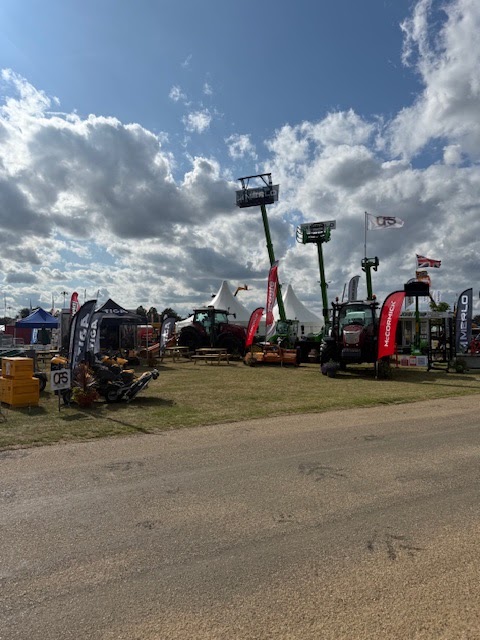 Telehandlers with booms raised at an agricultural show
