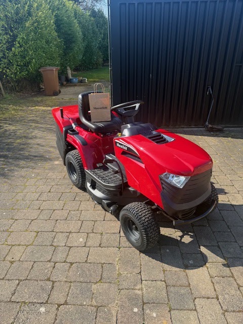 A red ride-on lawn tractor ready for collection