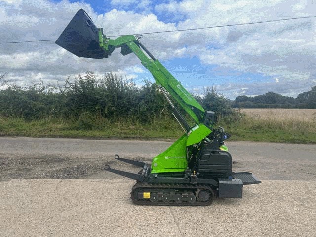Green Cingo M12.3 tracked carrier with its handler arm raised on the yard